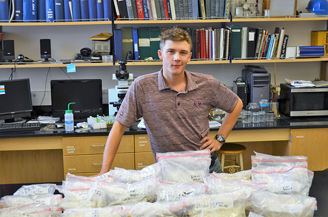 Cole with samples he has collected from around the world.