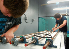 Fitting the rods that will hold the cylindrical tanks to the table.