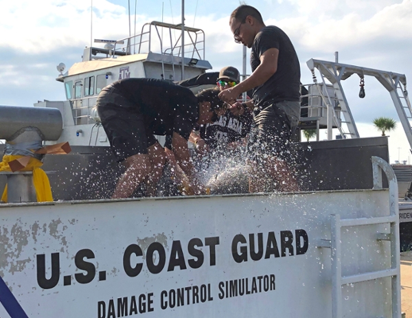 MESSO and vessel operations staff and crew members work together to plug a simulated pipe burst leak during training drills on the U.S. Coast Guard’s damage control simulator Friday morning. 