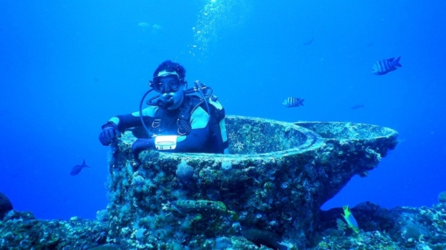 Calderon demonstrating the large size of the cut-off leg of a gas production platform during a monitoring dive. (FGBNMS/MacMillan).