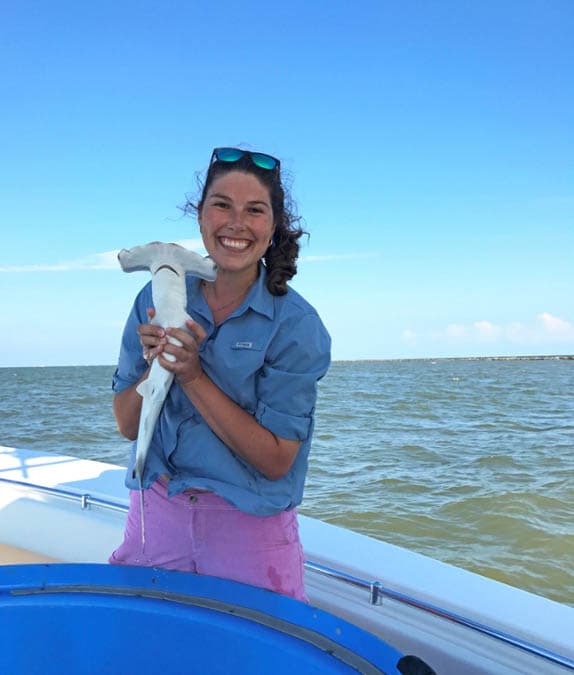 Marine Biology Ph. D. student Dr. Lauren Eve Simonitis poses with a juvenile scalloped hammerhead shark, one of the sub-species she recently discussed on a special "Sharkfest" episode of the Overheard at National Geographic podcast. 