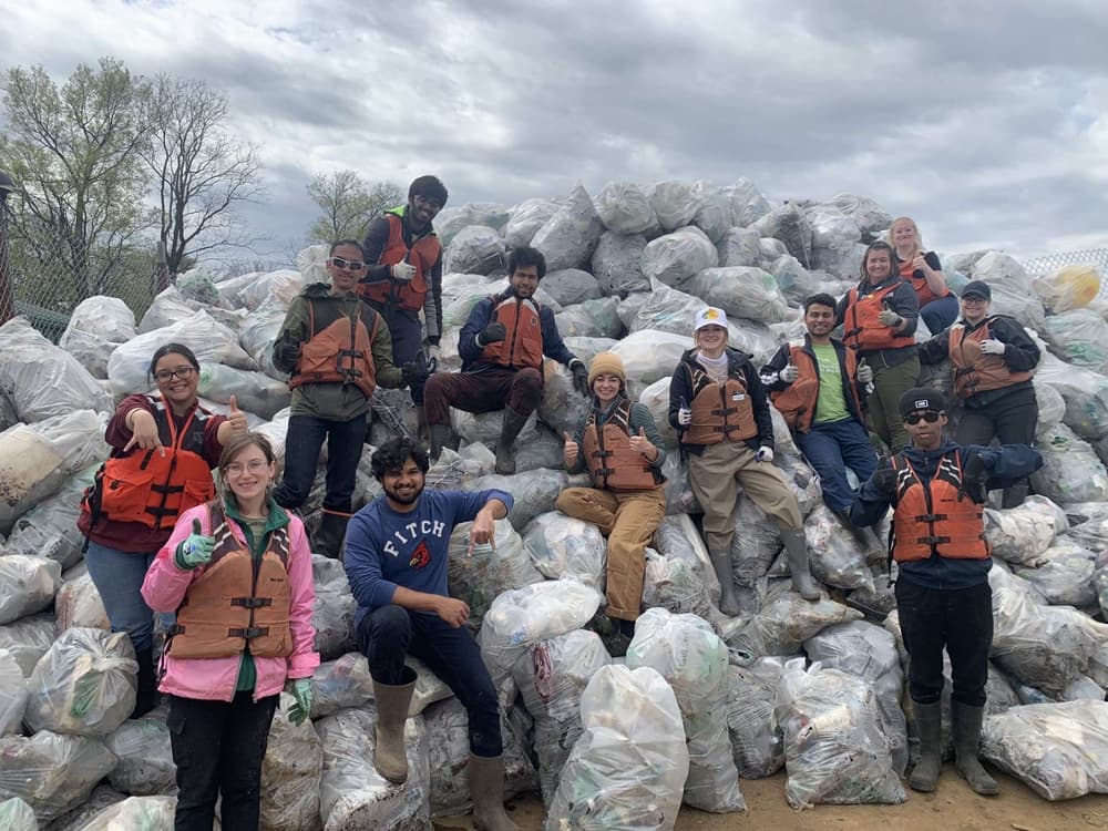 Students from Texas A&M University at Galveston joined by students from other universities standing in front of trash pulled out of McKellar Lake in Memphis, Tennessee. 