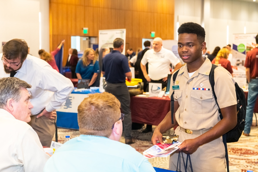A Texas A&M Maritime Academy cadet speaking with a prospective employer at the Spring Career Fair.